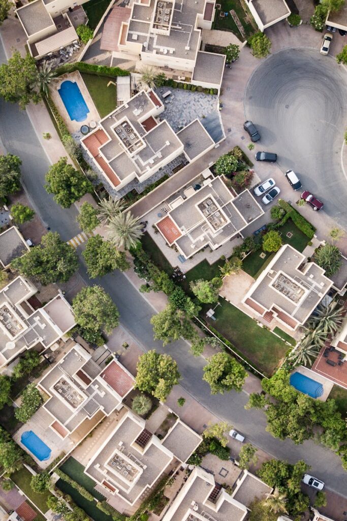 Explore a stunning aerial view of a residential area in Dubai with lush greenery and swimming pools.